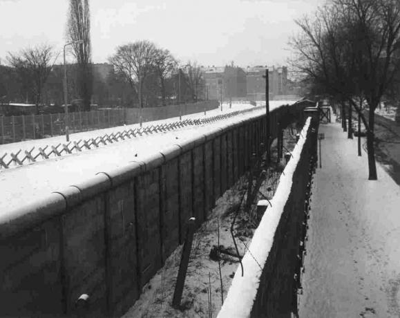 Liebenstrasse skats uz Berlīnes mūri ar iekšējo sienu, tranšeju un barikādēm.