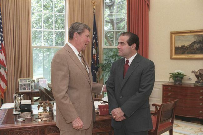 Prezidents Ronalds Reigans sarunājas ar Augstākās tiesas tiesneša kandidātu Antonīnu Skaliju ovālajā kabinetā, 1986.