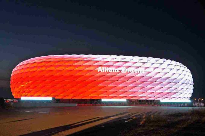 pa dienu balts, Allianz arēnas skulpturālais ārpuse naktī mirdz sarkanā krāsā