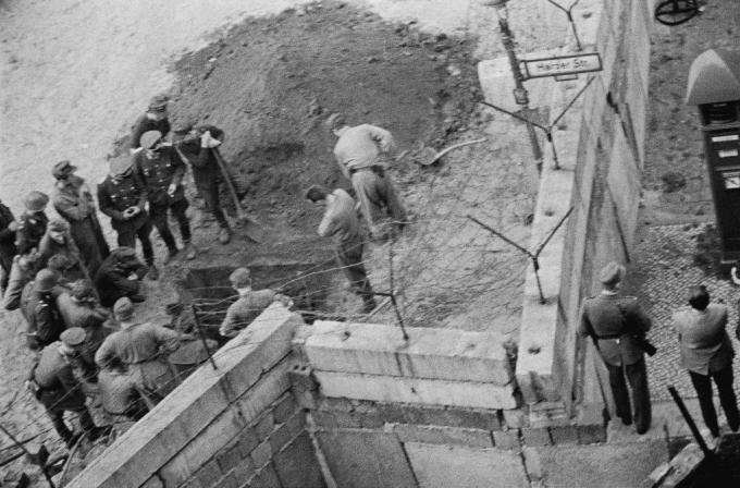 Austrumvācijas karavīru grupa izmeklē tuneli, kas izrakts zem Berlīnes sienas.