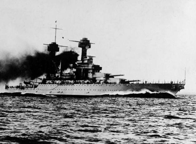 Līnijkuģis USS Colorado jūrā ar melniem dūmiem, kas nāk no piltuvēm.