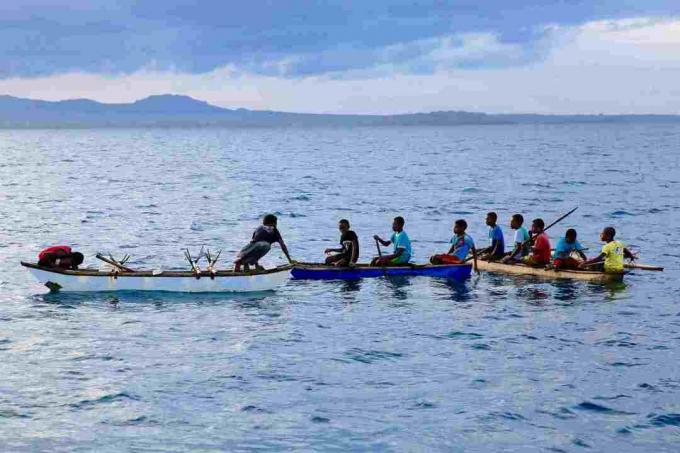 Jauni vīrieši kanoe laivās ziemeļrietumos Malakula, Vanuatu.