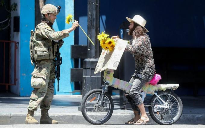Nacionālās gvardes karavīrs saņem protestētāja ziedu miermīlīgas demonstrācijas laikā par Džordža Floida nāvi Holivudā 2020. gada 3. jūnijā.