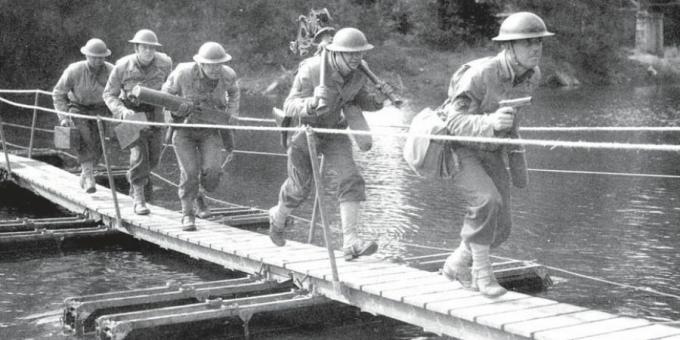 Amerikāņu karavīri šķērso nelielu pontonu tiltu.