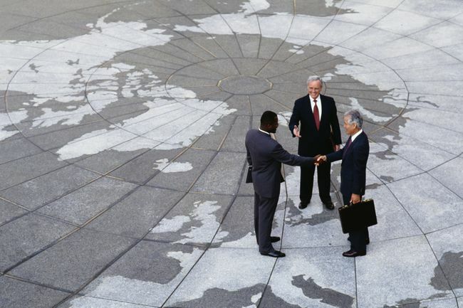  Ekonomiskais reģionālisms: uzņēmēji, kas kratot roku zemeslodes kartē.