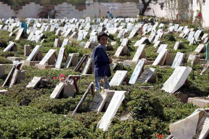 Kāds kapsēta Sana’a, Jemenā, staigā starp cilvēku kapiem, kuri tika nogalināti notiekošajā karā.